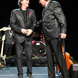 BJ Thomas and Mark James share a laugh on stage.